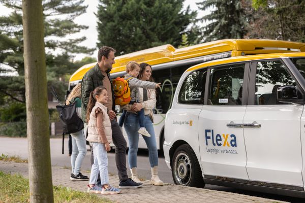 Familie vor einem Flexa-Fahrzeug